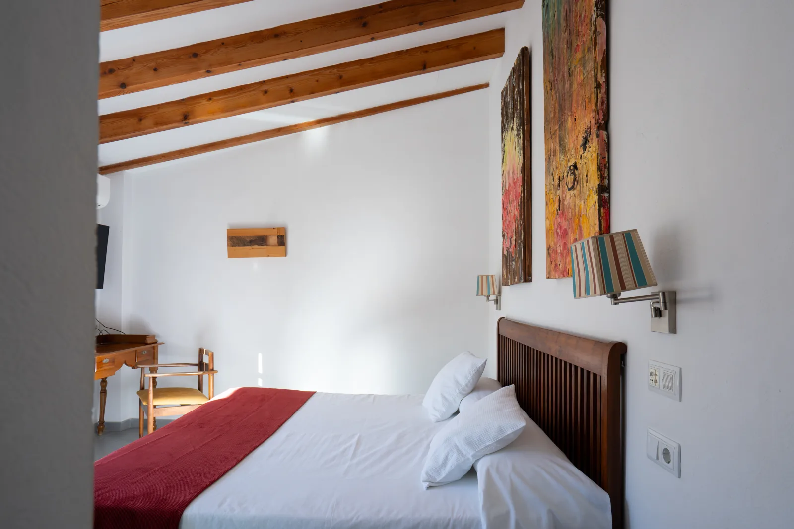 Cabecero con obras originales de Aina Cifre, arte en habitación de L'Hostal Pollença